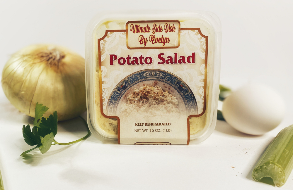 A container of potato salad sitting next to an onion.